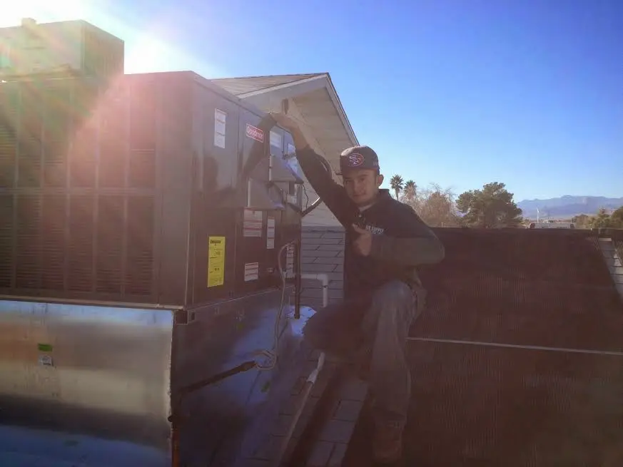 HVAC technician performing HVAC Inspection on a rooftop unit in Gardendale